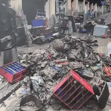 Hay un montón de basura en la acera frente a un edificio.