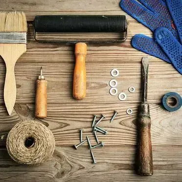 Una mesa de madera cubierta con un montón de herramientas y guantes.
