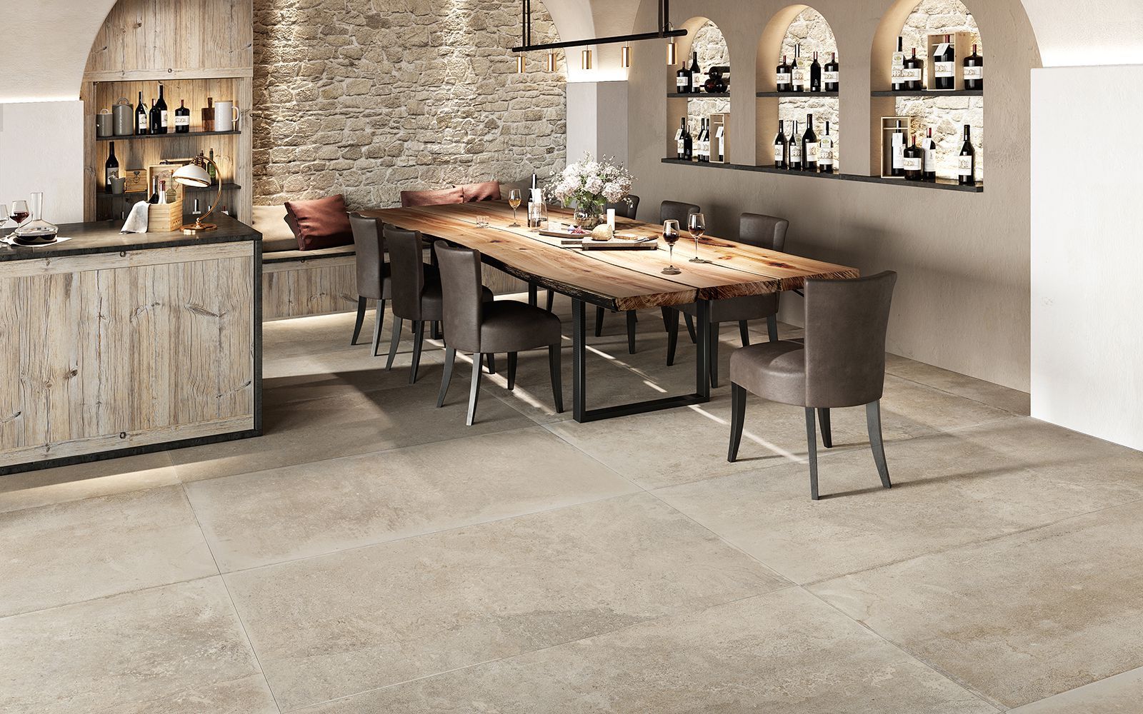 Salle à manger rustique et élégante avec une longue table en bois, des chaises, un mur en pierre et des étagères cintrées.