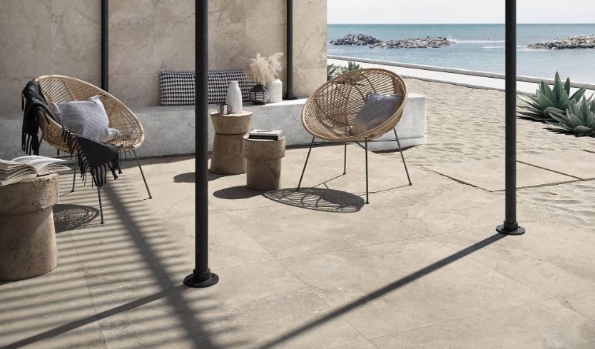 Terrasse en bord de mer avec chaises en osier.