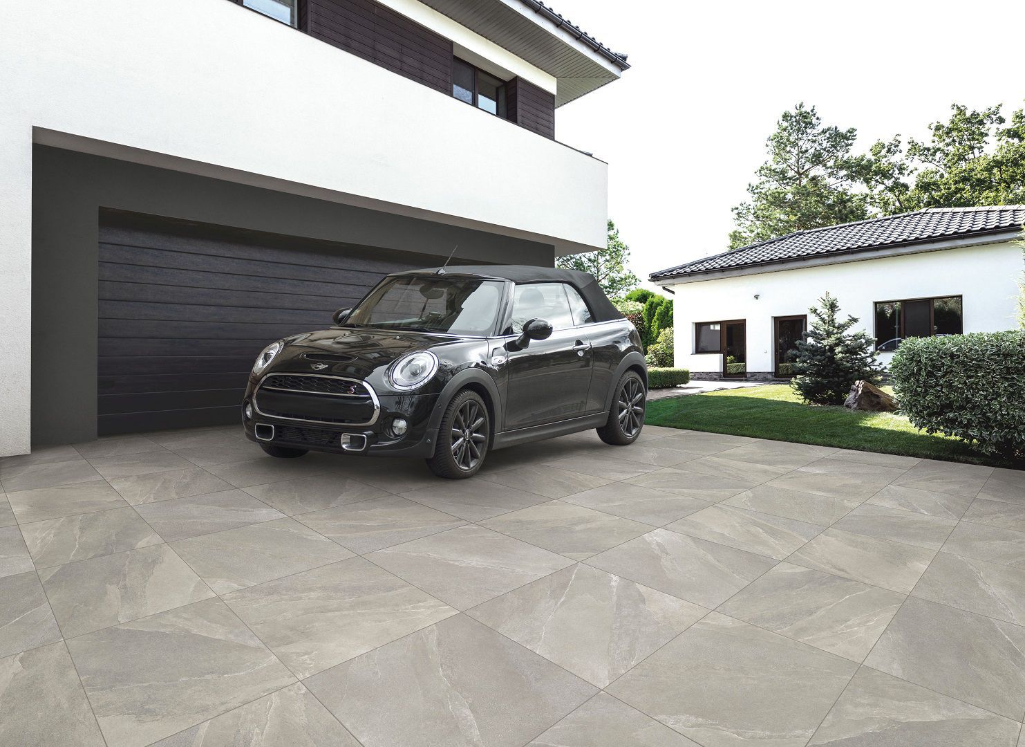 Une voiture noire est garée dans une allée moderne.