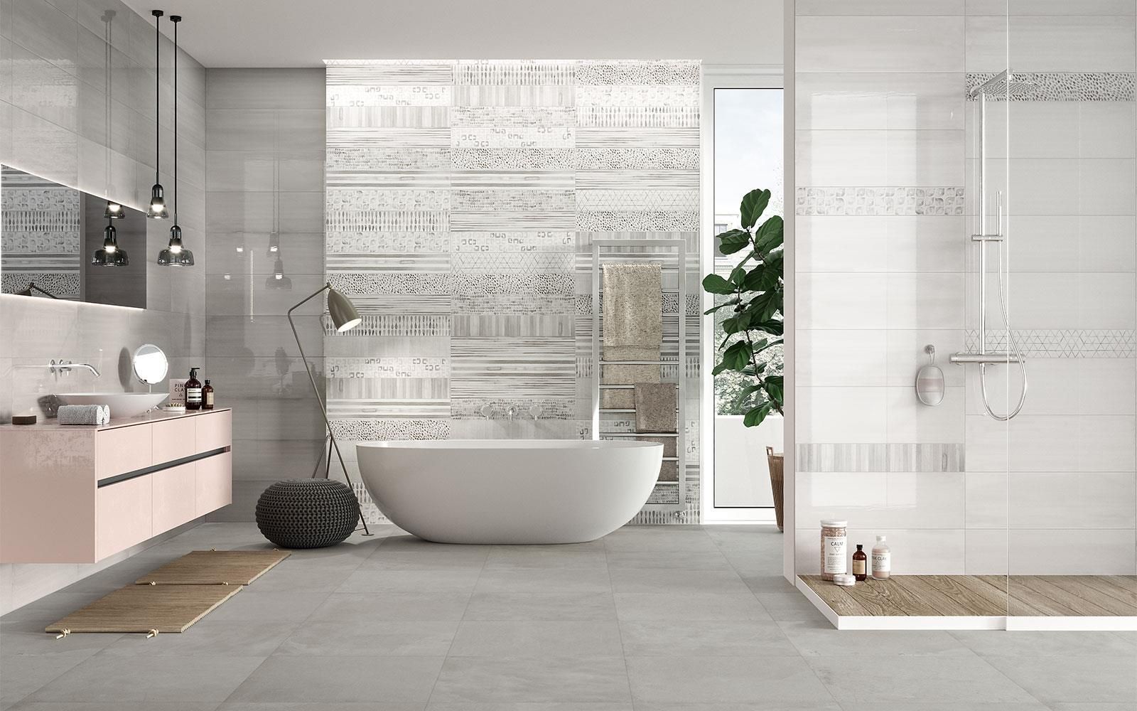 Salle de bains moderne et minimaliste avec baignoire îlot, douche en verre, sol gris et meubles rose pâle.