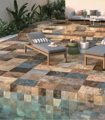 Patio avec marches carrelées, chaises longues et plantes en pot.