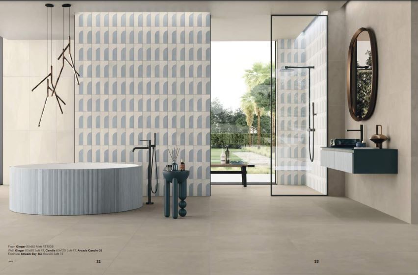 Salle de bains avec baignoire et mur carrelé à motifs.