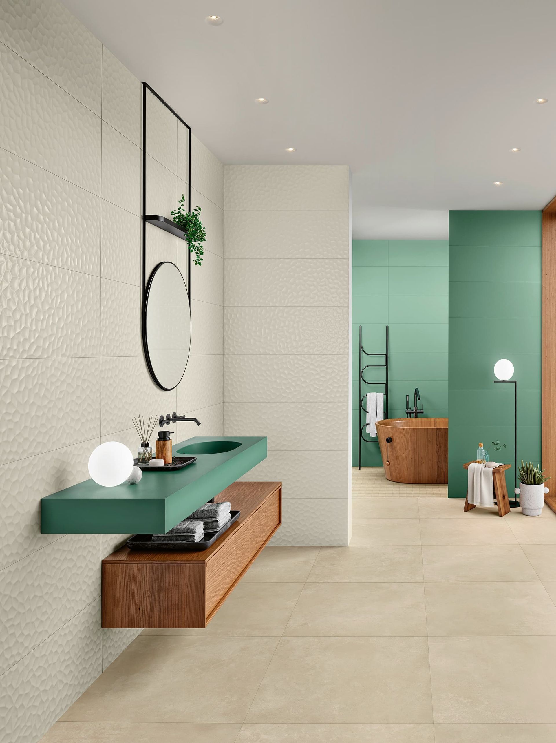 Salle de bains moderne avec meuble lavabo vert, miroir rond et touches de bois clair.