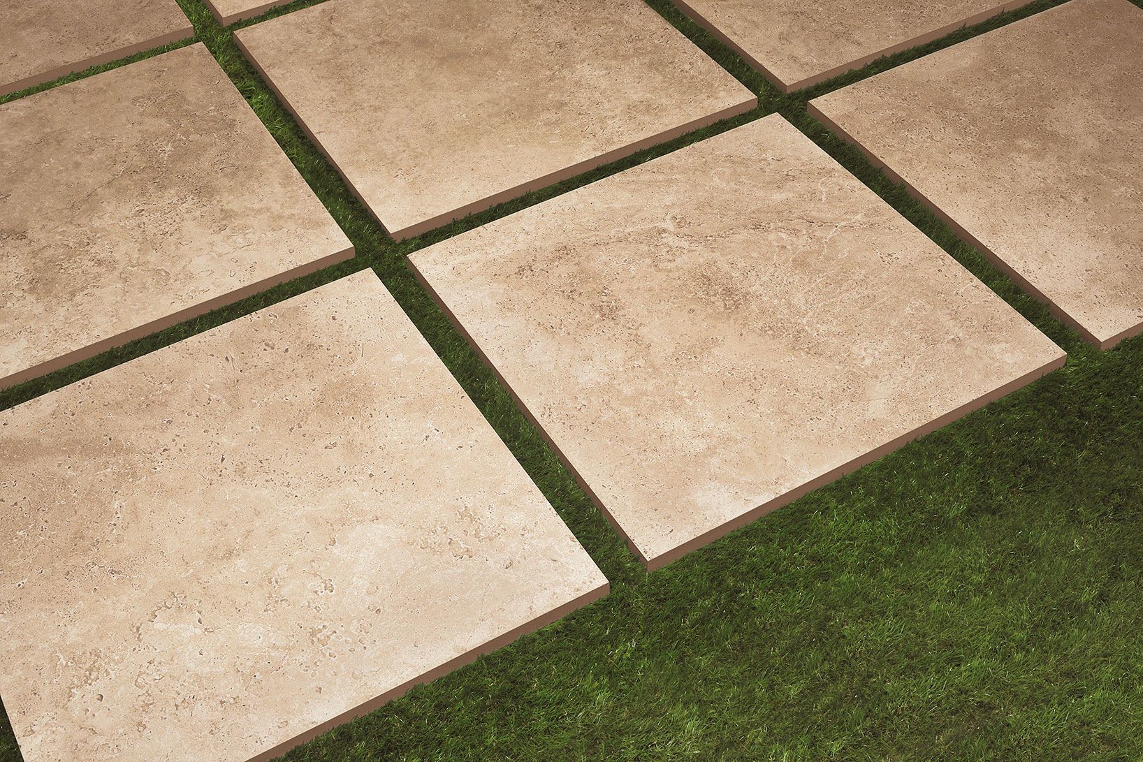 Dalles en pierre séparées par de l'herbe verte.