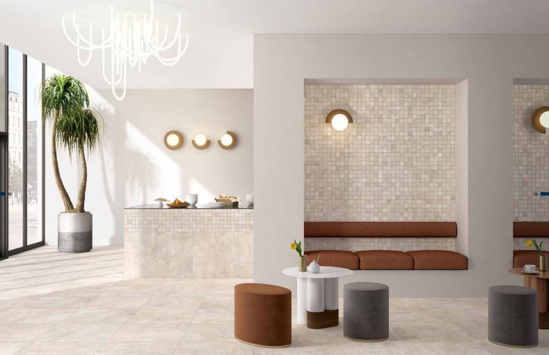 Pièce avec comptoir en pierre blanche, banquette et petits tabourets ronds près de grandes fenêtres