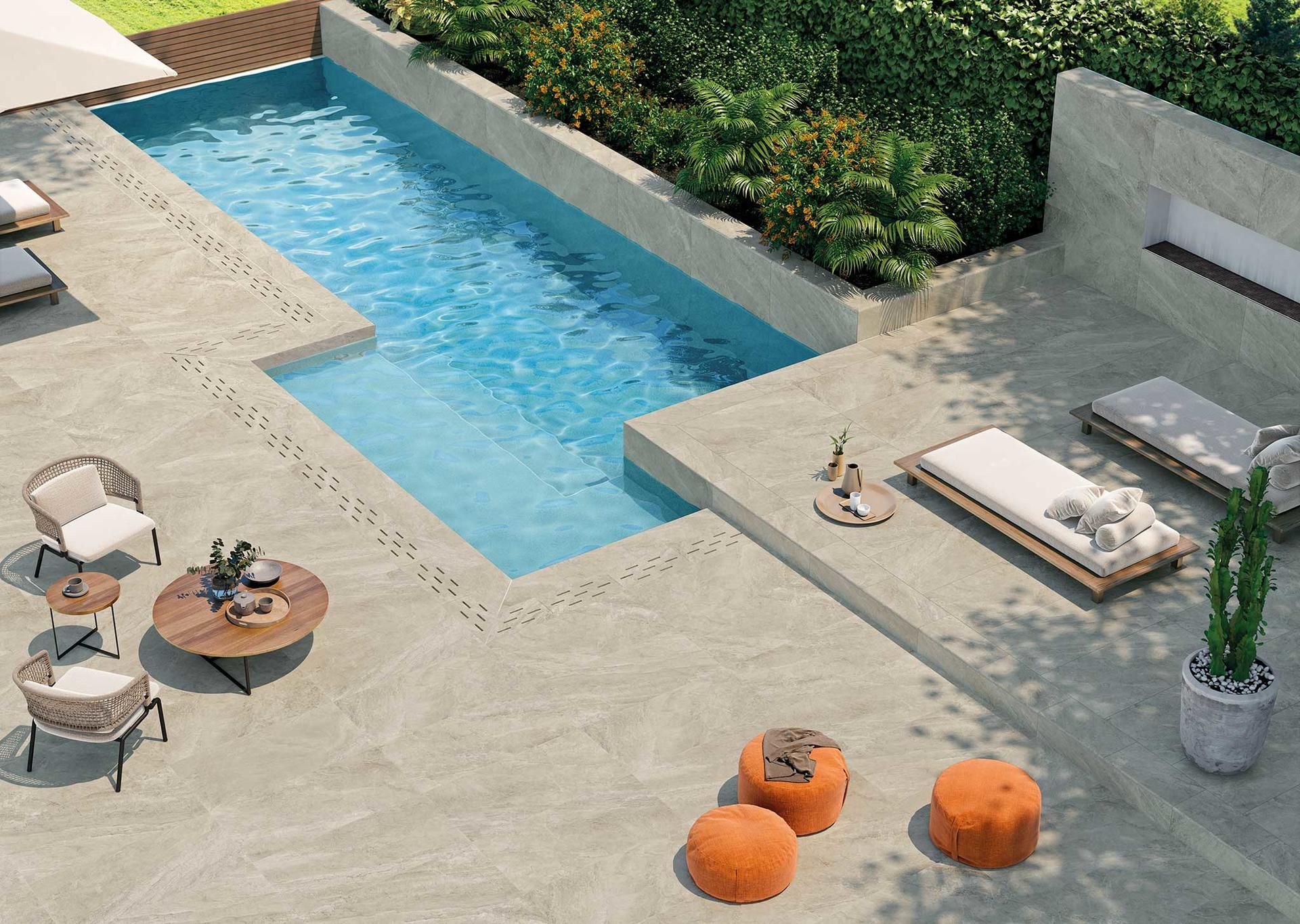 Patio moderne avec une piscine, une chaise longue, une table et des poufs orange.