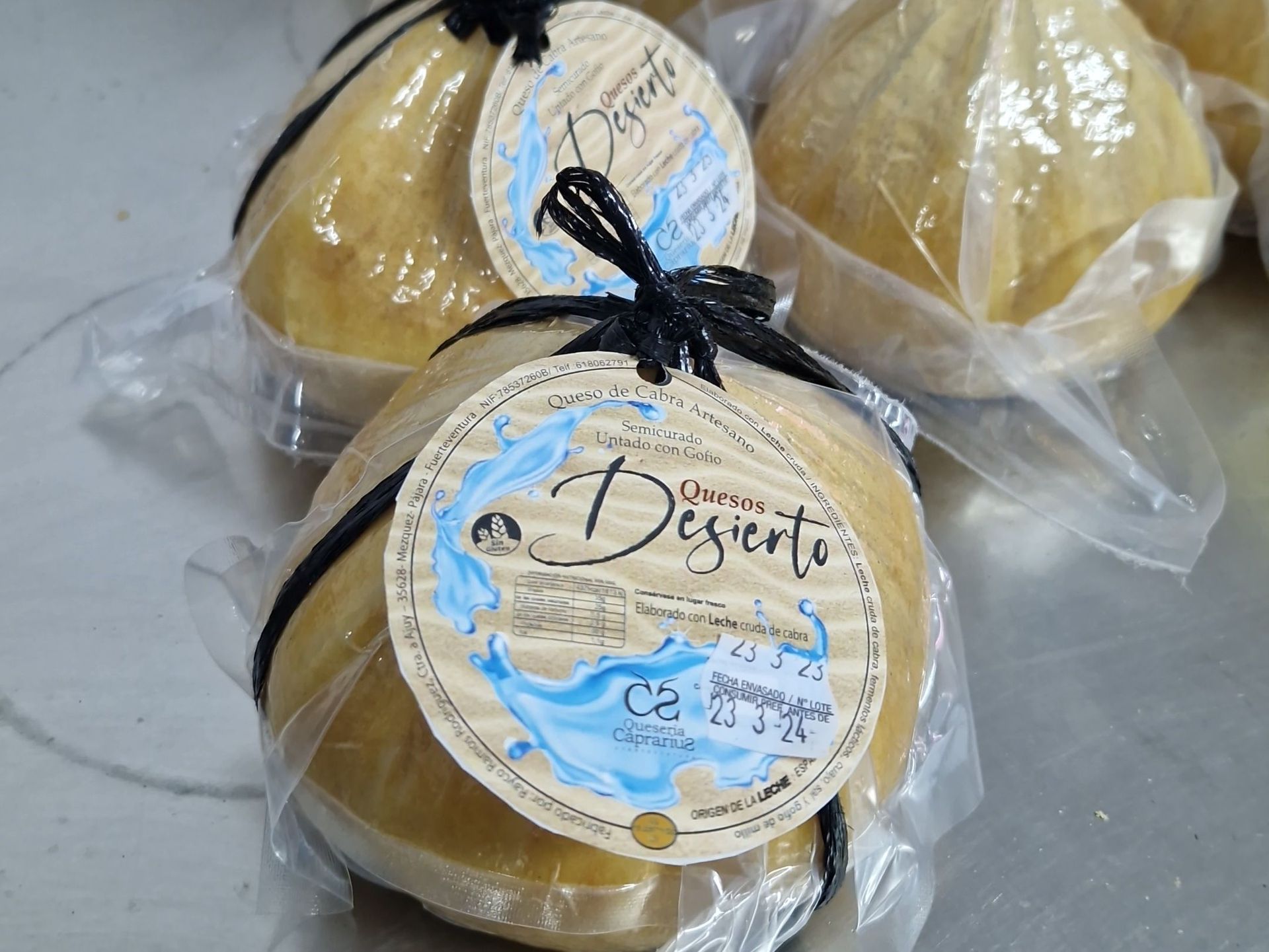 Tres bolas de queso deserto están envueltas en plástico y atadas con una cuerda negra.