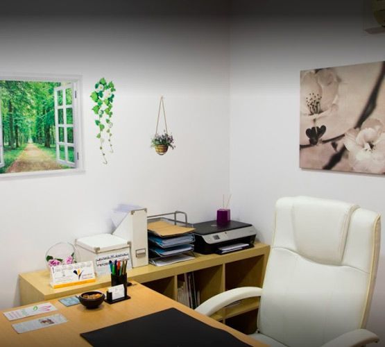 Una habitación con un escritorio y una silla y un cuadro en la pared.