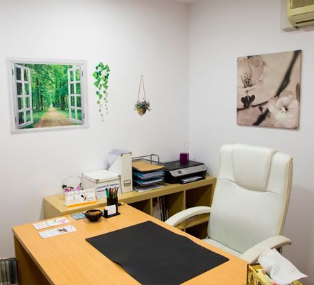 Hay una imagen de un bosque en la pared encima del escritorio.