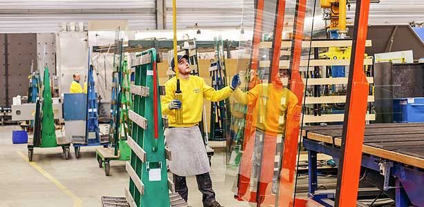 Professionnel près d'une plaque de verre dans un atelier.