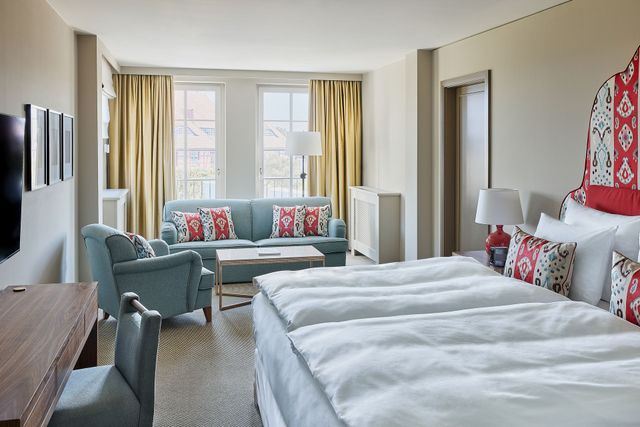 Doppelzimmer Meerseite ohne Balkon - Blick ins Zimmer mit Couch, Sessel und Kingsize-Bett