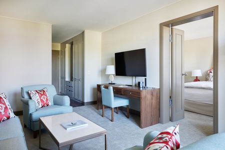 Unsere Junior Suite mit Ikat-Motiven Junior Suite im Strandhotel Zingst, mit großem Bett und geschwungenem Headboard mit Ikat-Motive.