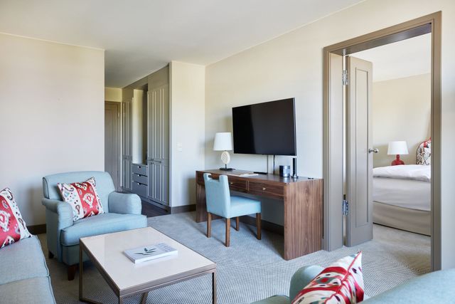Junior Suite Meerseite mit Balkon - Blick ins Zimmer auf einen Sessel und Schreibtisch 