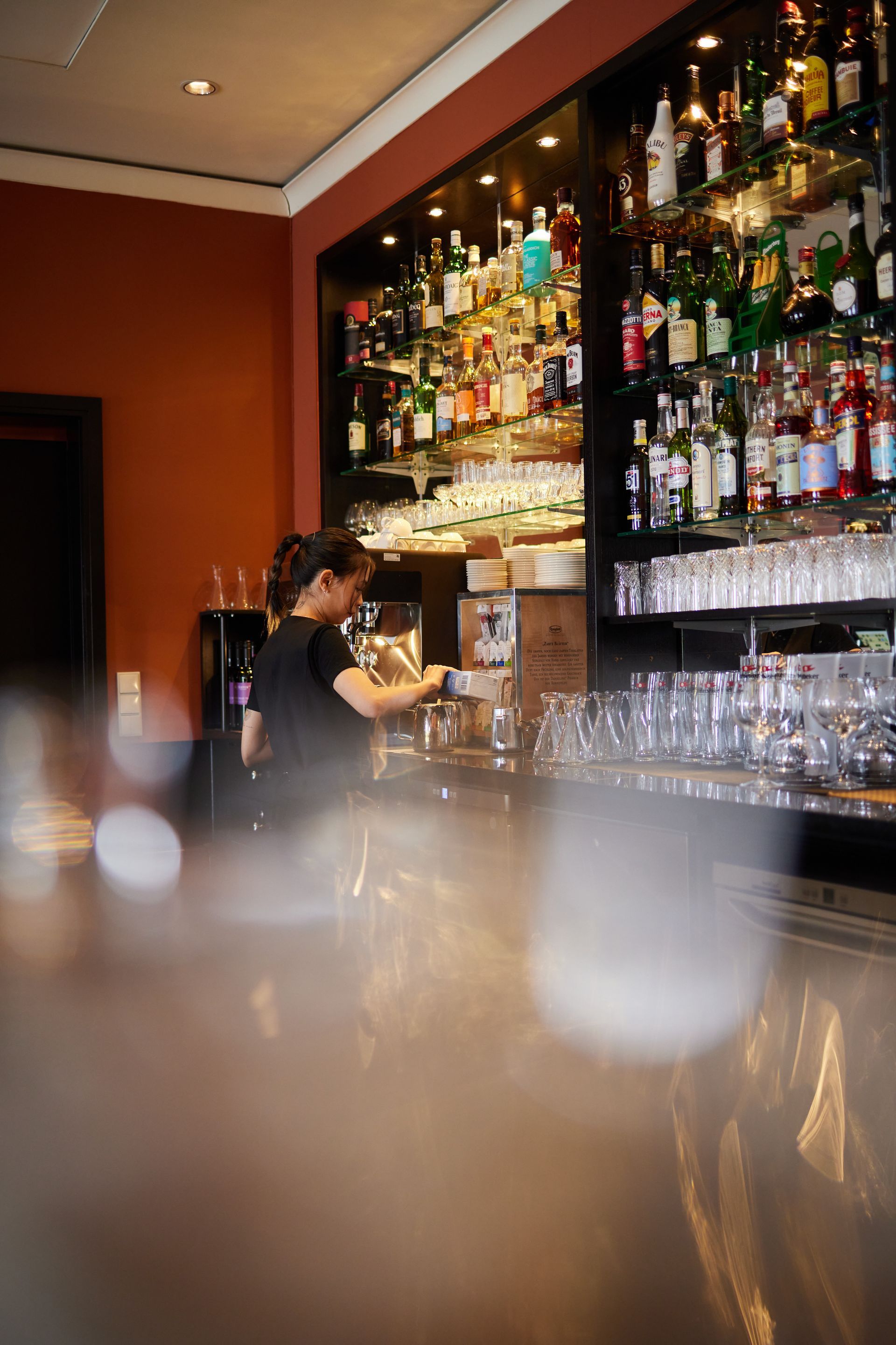 Barkeeperin macht Kaffee hinter Hotelbar.