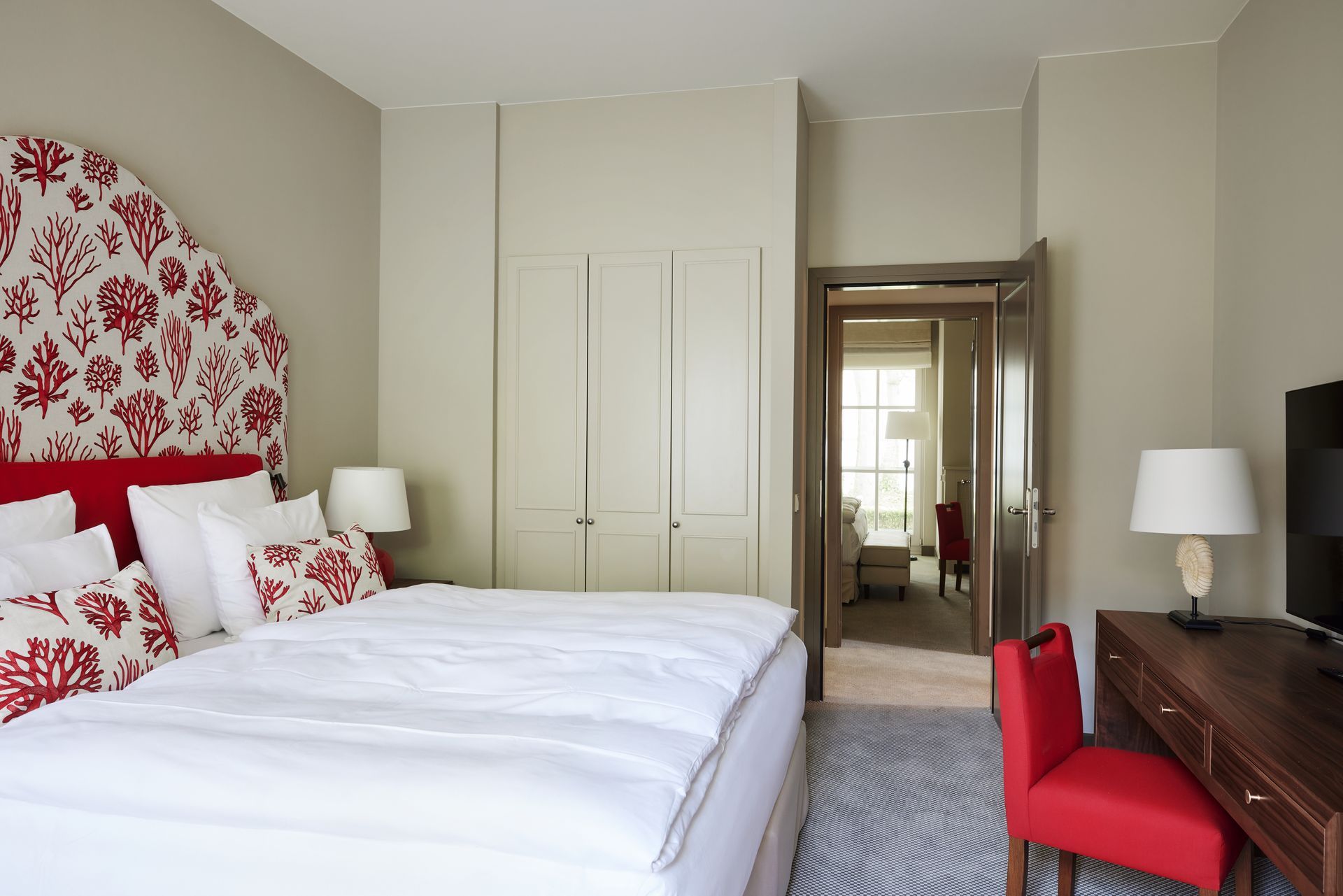 Schatten einer Person mit erhobenen Armen in einem Pool, der auf den gefliesten Boden darunter fällt, blaues Wasser.