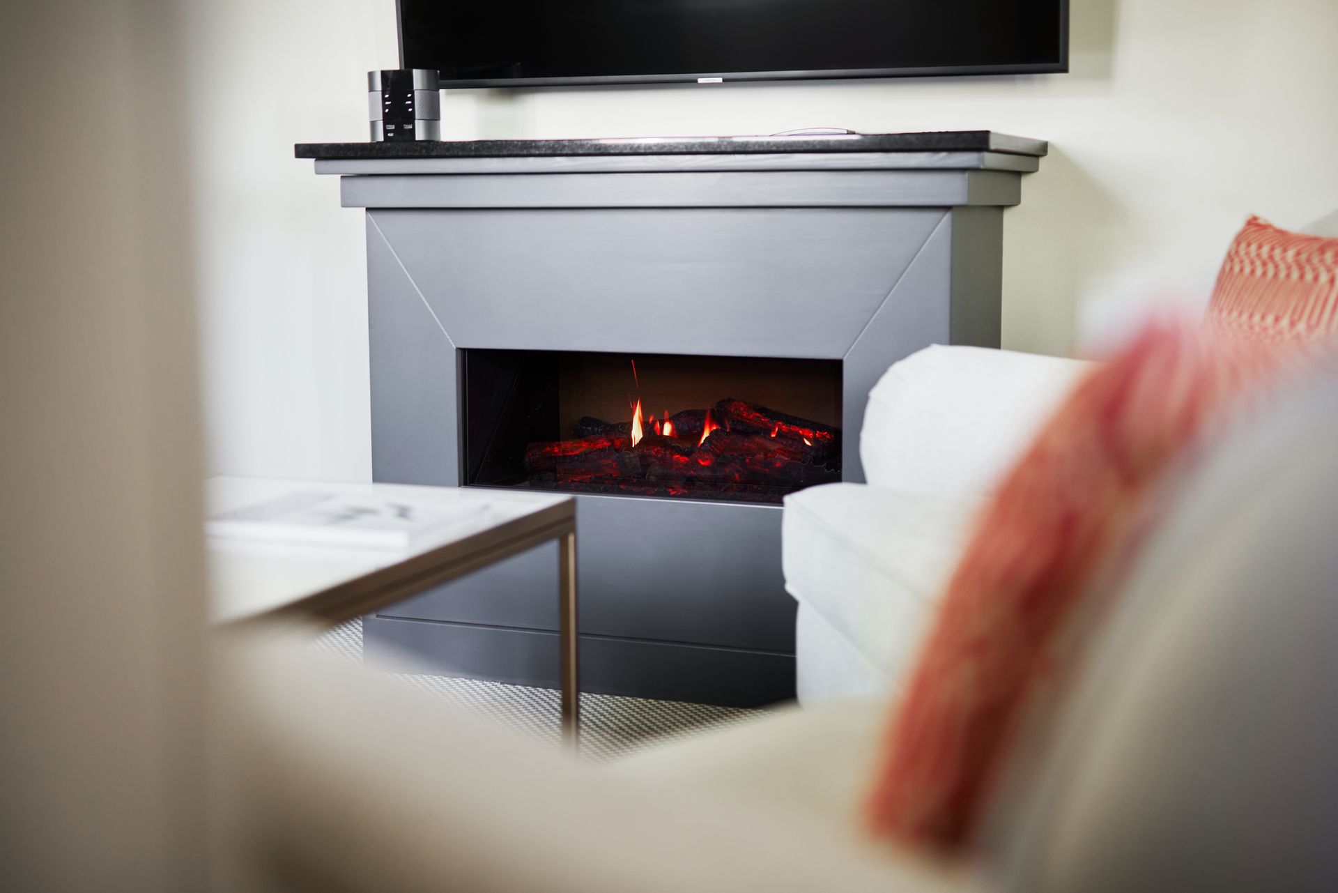 Schatten einer Person mit erhobenen Armen in einem Pool, der auf den gefliesten Boden darunter fällt, blaues Wasser.