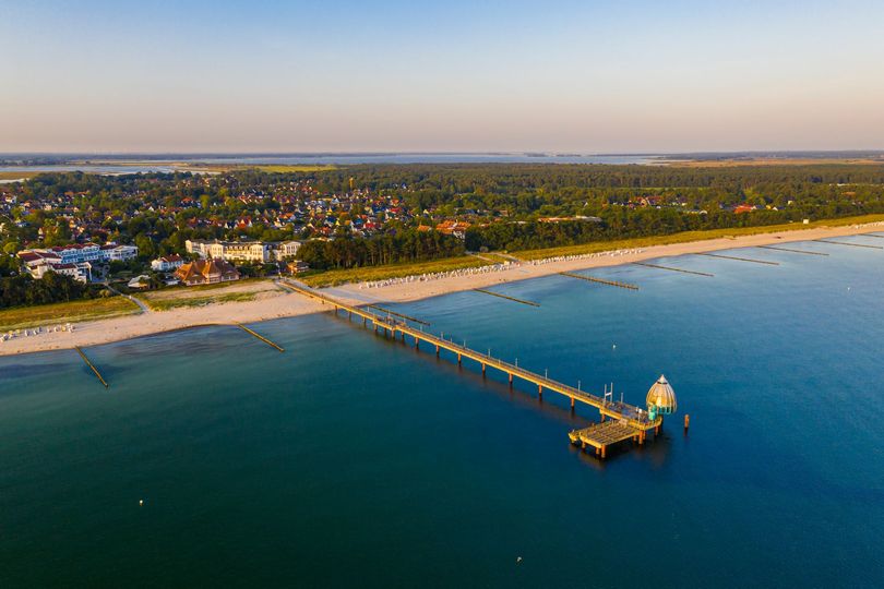 Strandhotel Zingst - Einatmen. Ausatmen. Ankommen. Drohnenansicht auf die Seebrücke und das Strandhotel Zingst an der Ostsee – ein Hotel mit Meerblick.