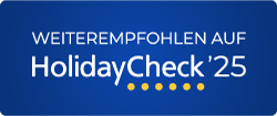 „Empfohlen auf HolidayCheck 25“. Blaues rechteckiges Badge mit weißem und goldenem Text/Punkten.