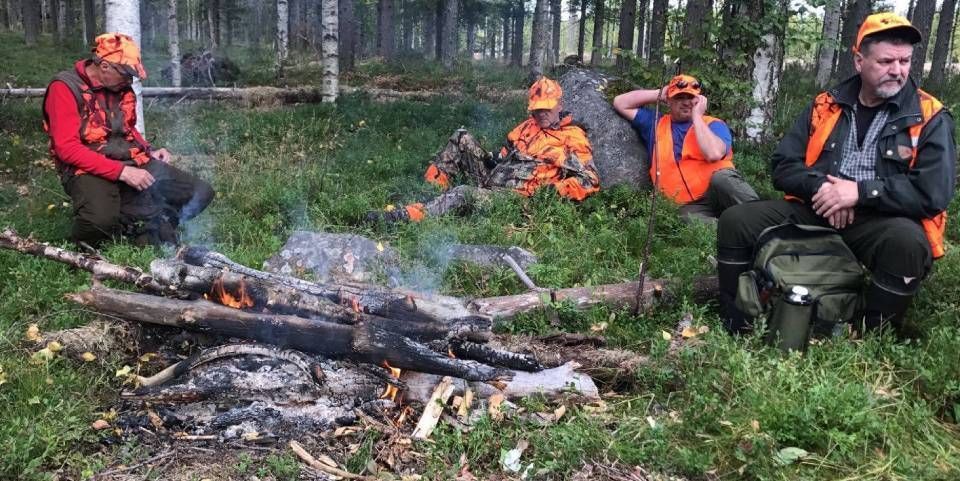 Metsästysseurue tauolla nuotiolla