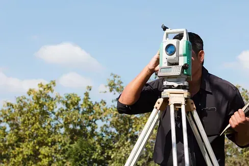 Un hombre está mirando a través de un telescopio sobre un trípode.
