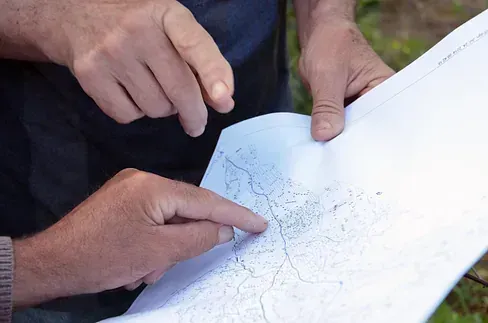 Un hombre señala un mapa con su dedo.