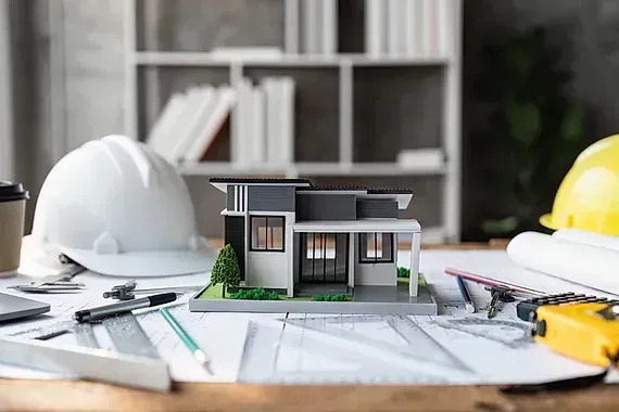 Una casa modelo está colocada encima de una mesa de madera.