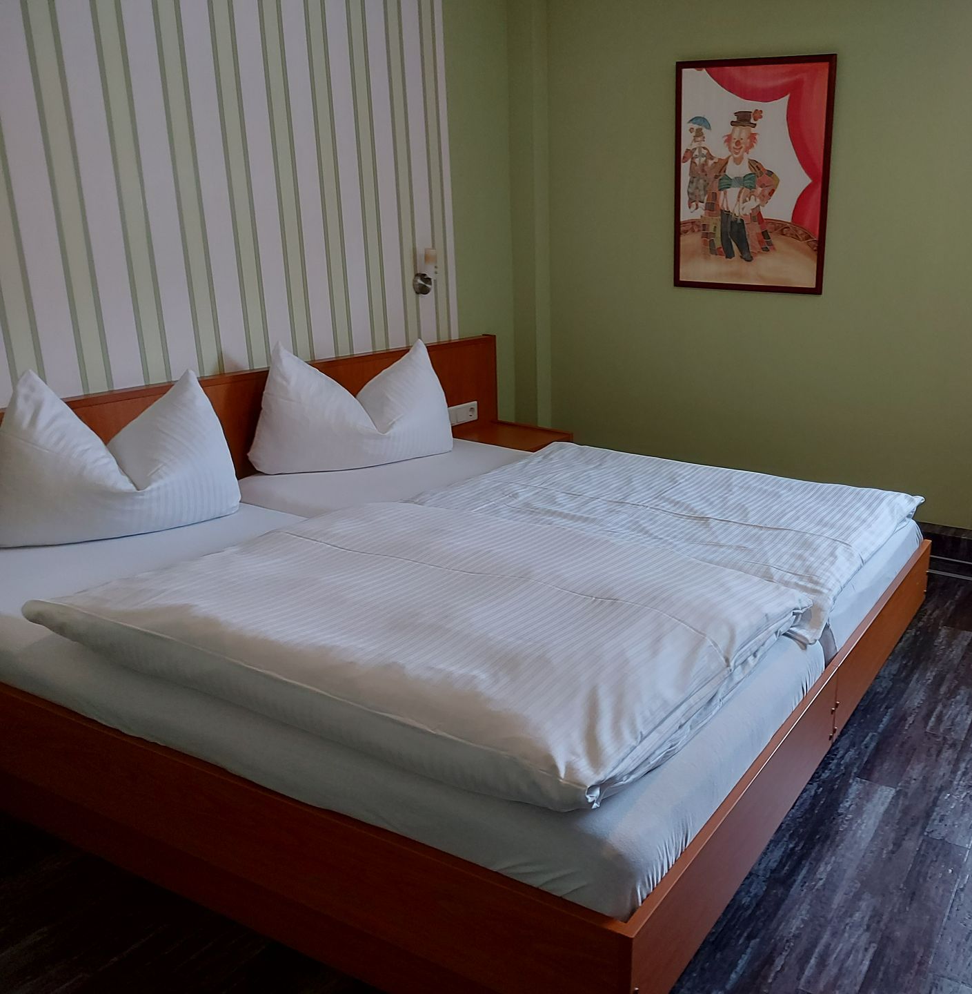 Ein Schlafzimmer mit zwei Betten und einem Bild an der Wand