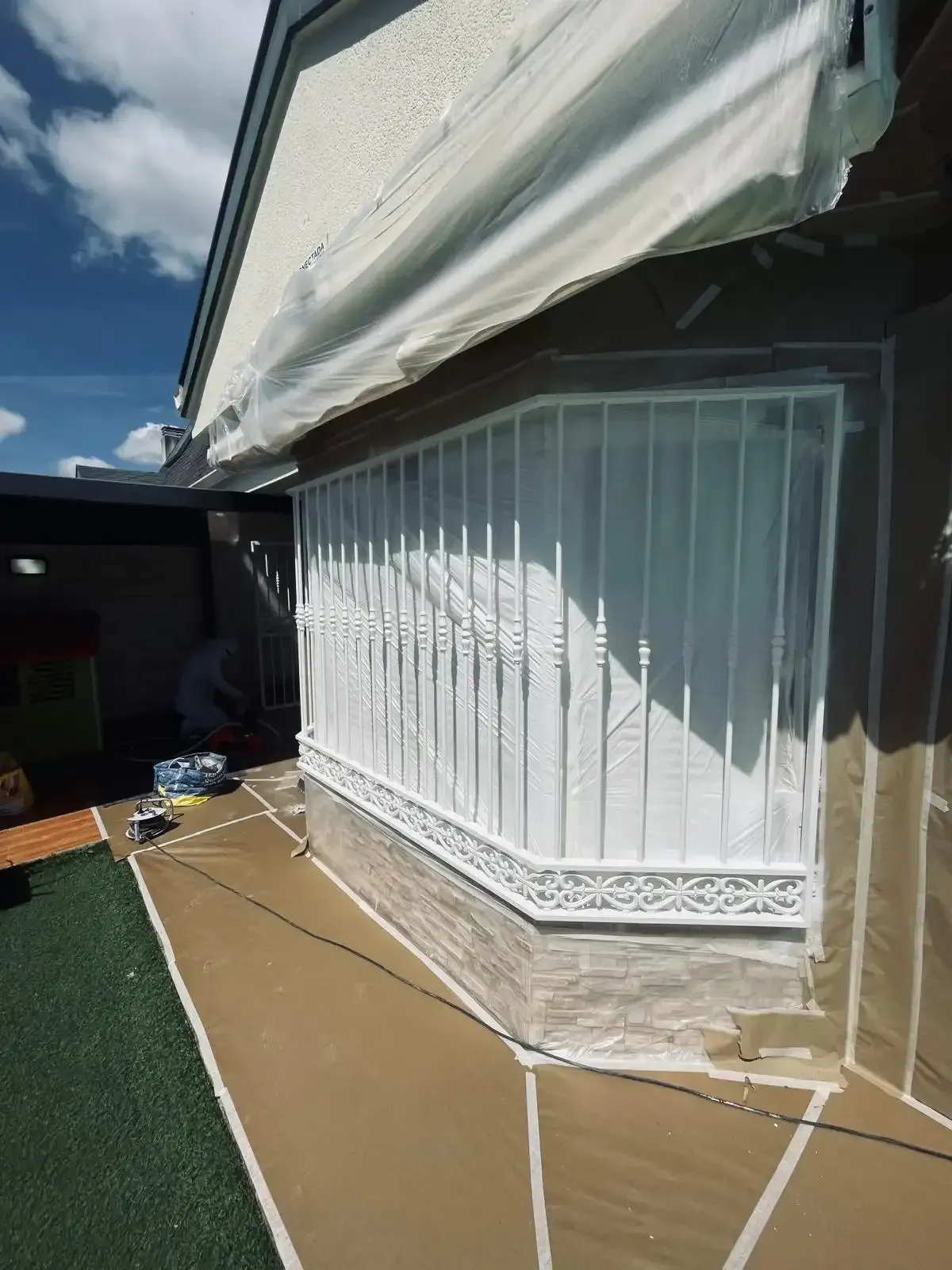 Patio exterior con ventanal blanco cerrado y toldo retráctil.