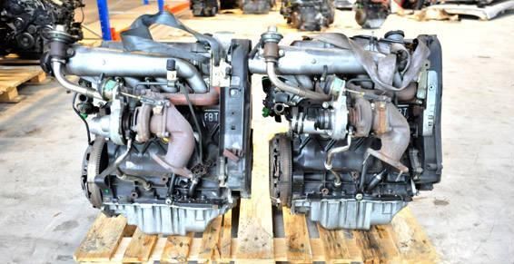 Deux moteurs diesel sur des palettes en bois, divers tubes et composants métalliques visibles.