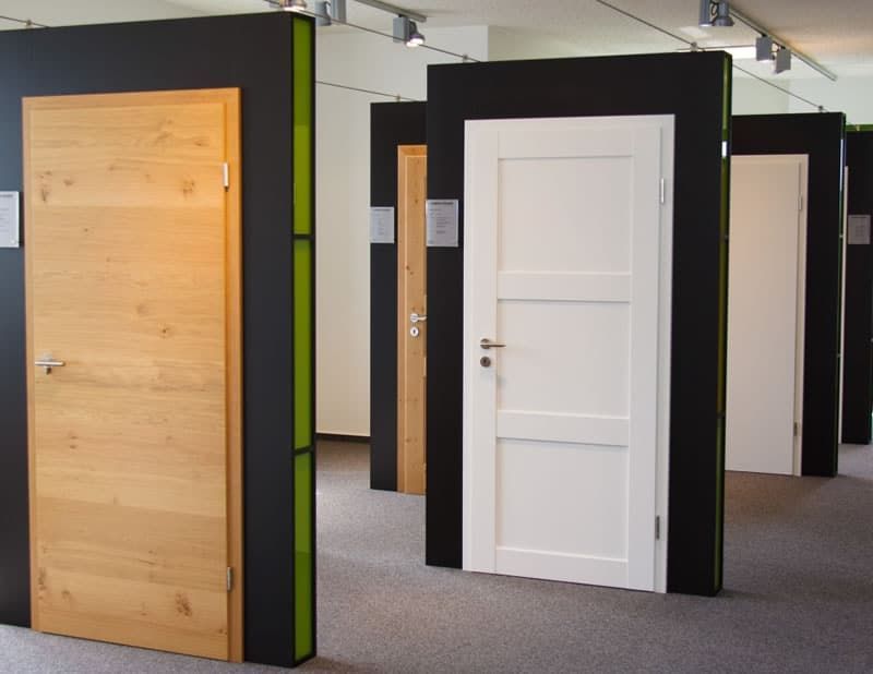 Ausstellungsraum mit verschiedenen Innentüren, darunter eine weiße Paneeltür und eine helle Holztür