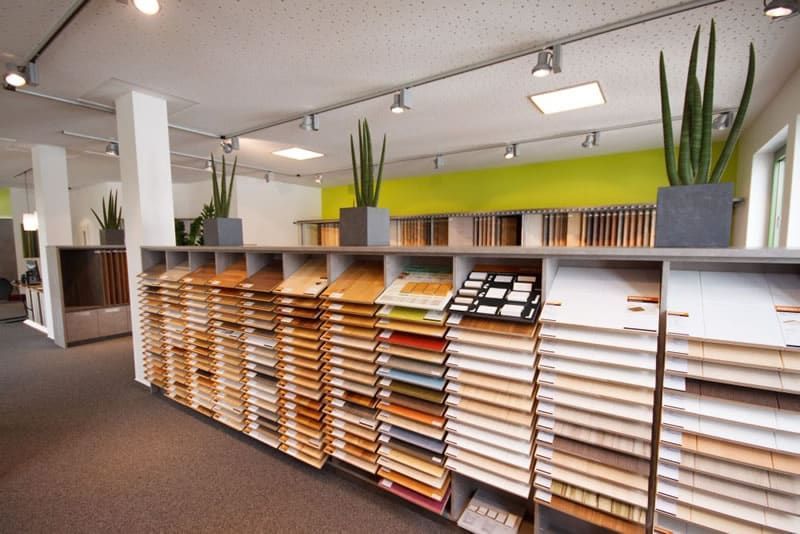 Modernes Bürointerieur mit Regalen voller bunter Papiermuster und einer Topfpflanze darüber.