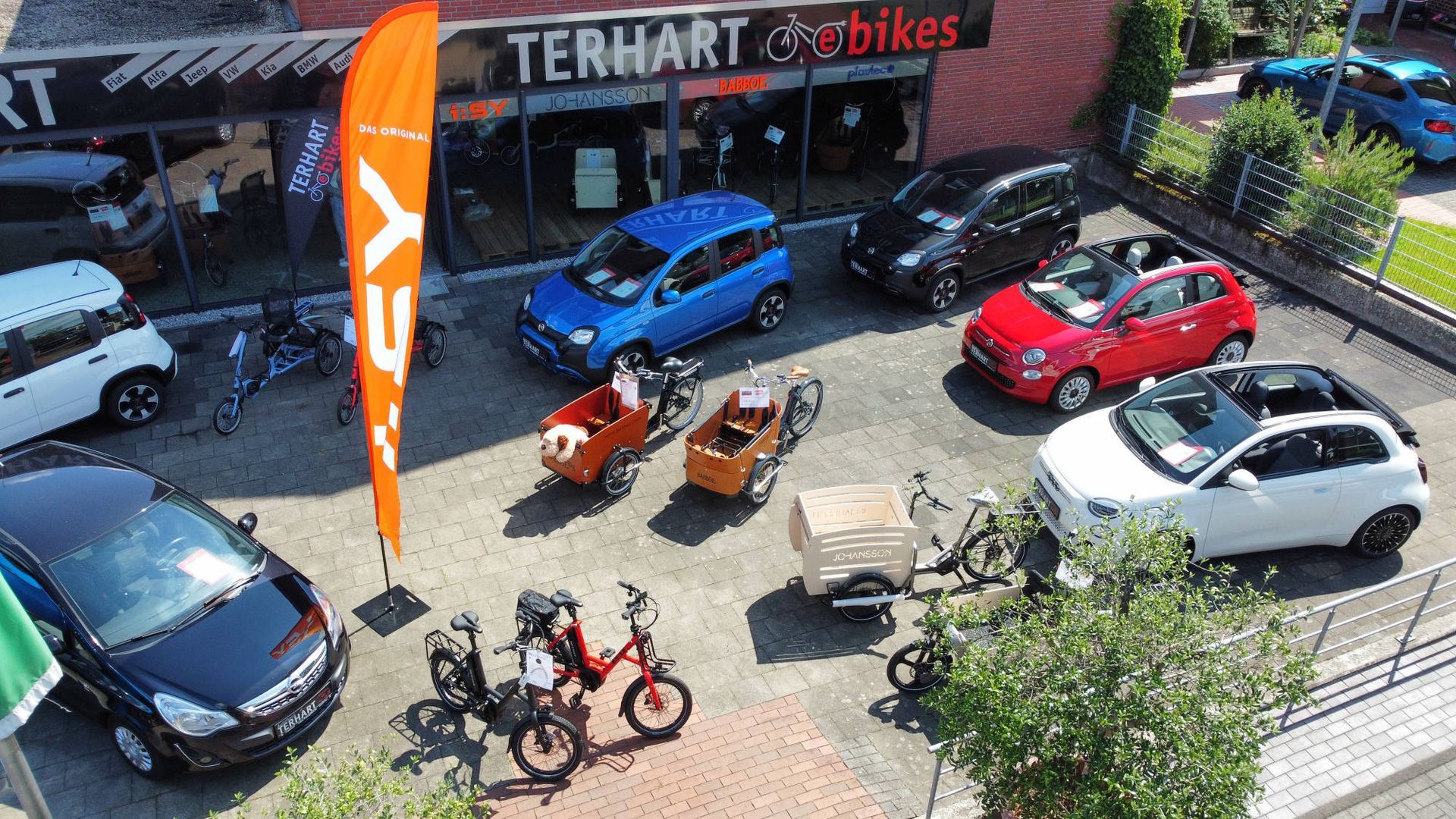 Eine Gruppe von Autos parkt vor einem Geschäft namens Terhart Bikes