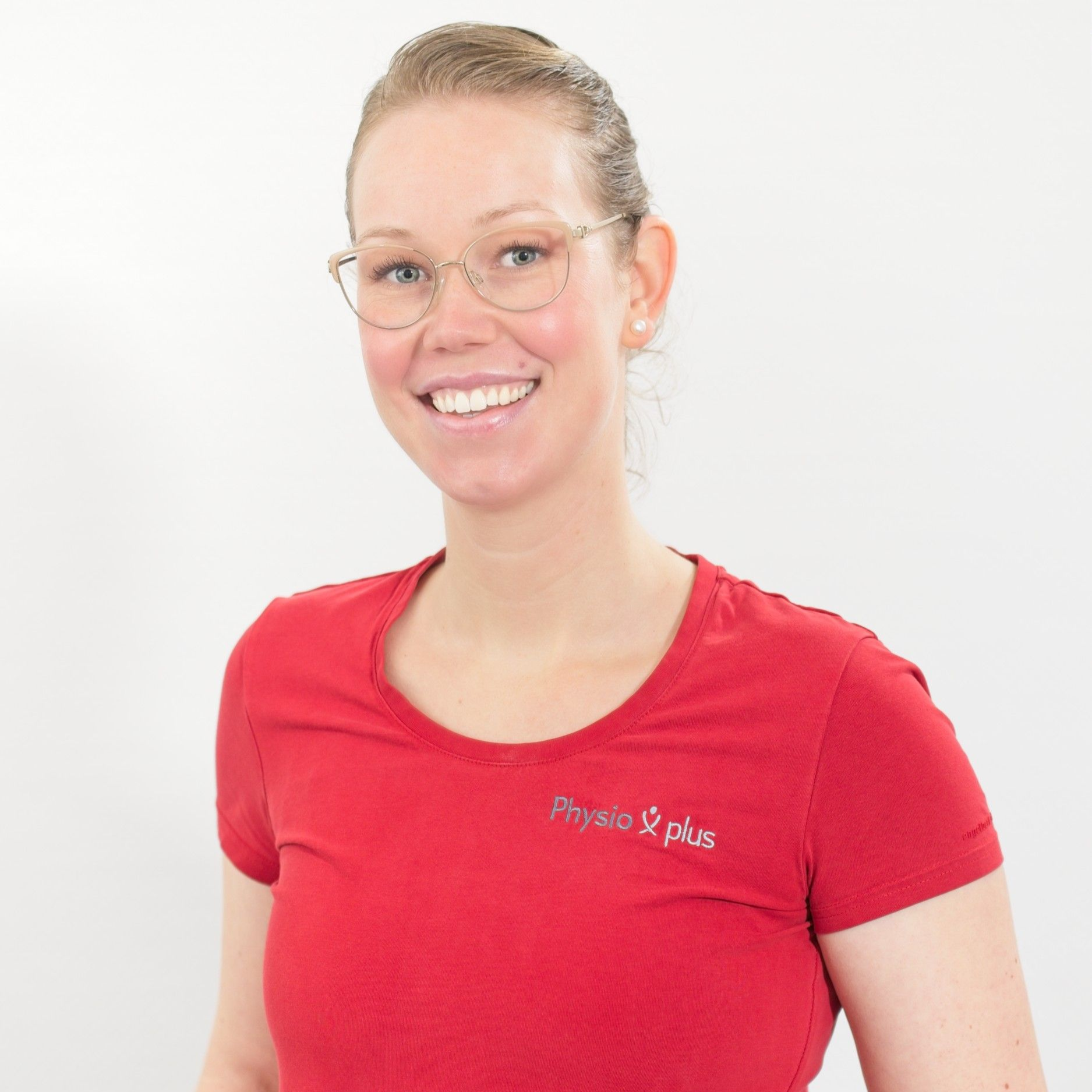 Eine Frau in einem roten Hemd lächelt in die Kamera