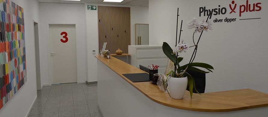 Ein Flur mit einer Holztheke und einem Schild mit der Aufschrift Physio Plus