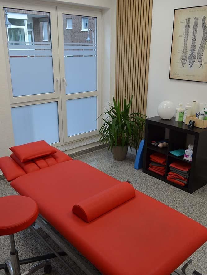 Ein Zimmer mit einem roten Bett und einem Hocker