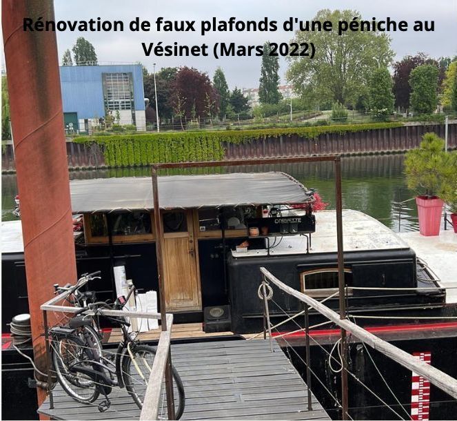 Rénovation des faux plafonds d'une péniche à Vésinet (mars 2022). Un vélo sur le quai. Péniche noire et rouge sur l'eau.