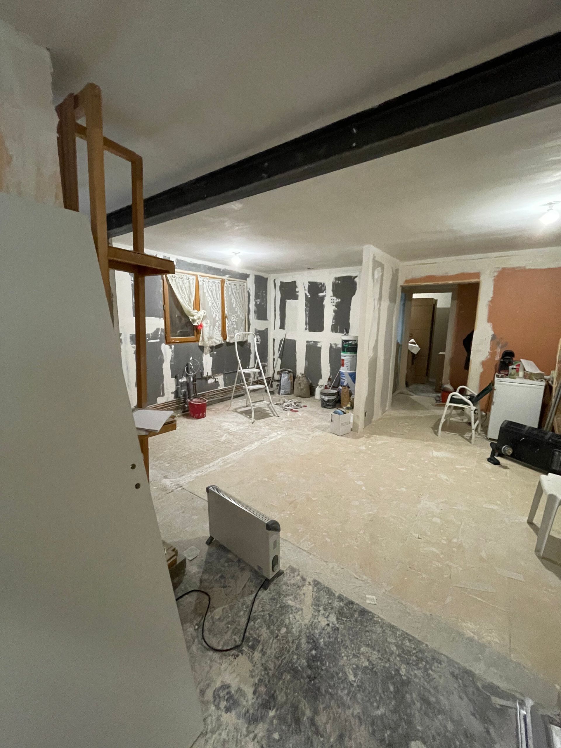 Pièce en rénovation avec cloisons sèches et matériaux de construction apparents.