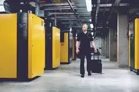 Una mano enguantada ajusta un manómetro en una máquina. Primer plano de diales, tuberías y cables.