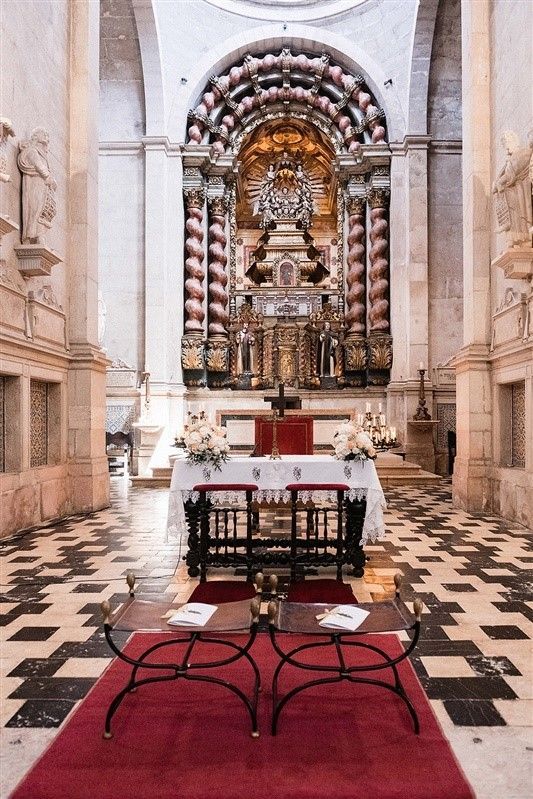 Uma igreja com uma mesa e cadeiras em frente ao altar.