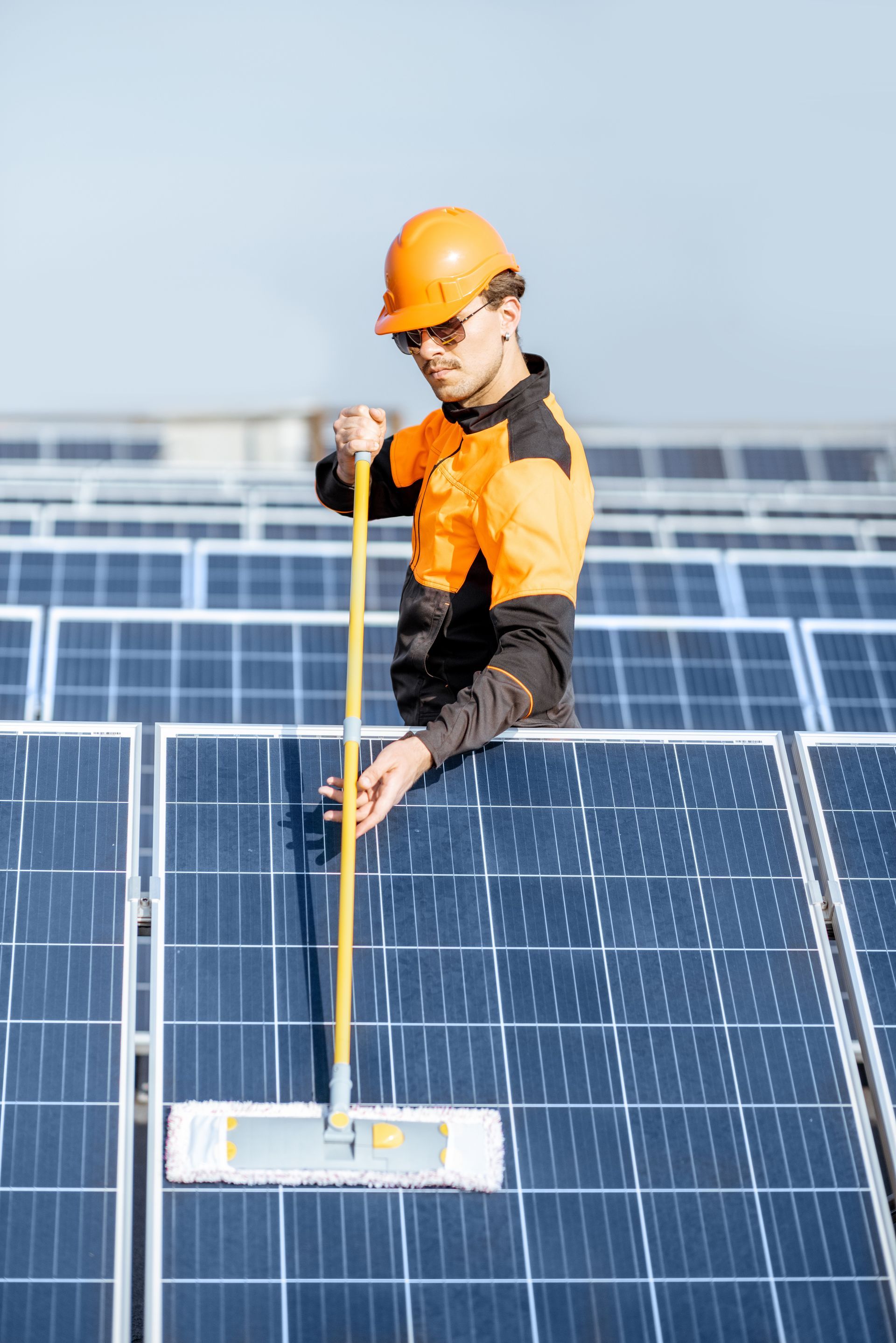 Personne utilisant une serpillière pour nettoyer des panneaux solaires