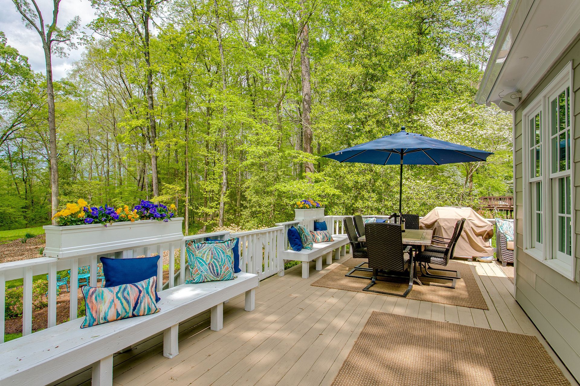 Terrasse d'une maison en bois avec rambarde blanche