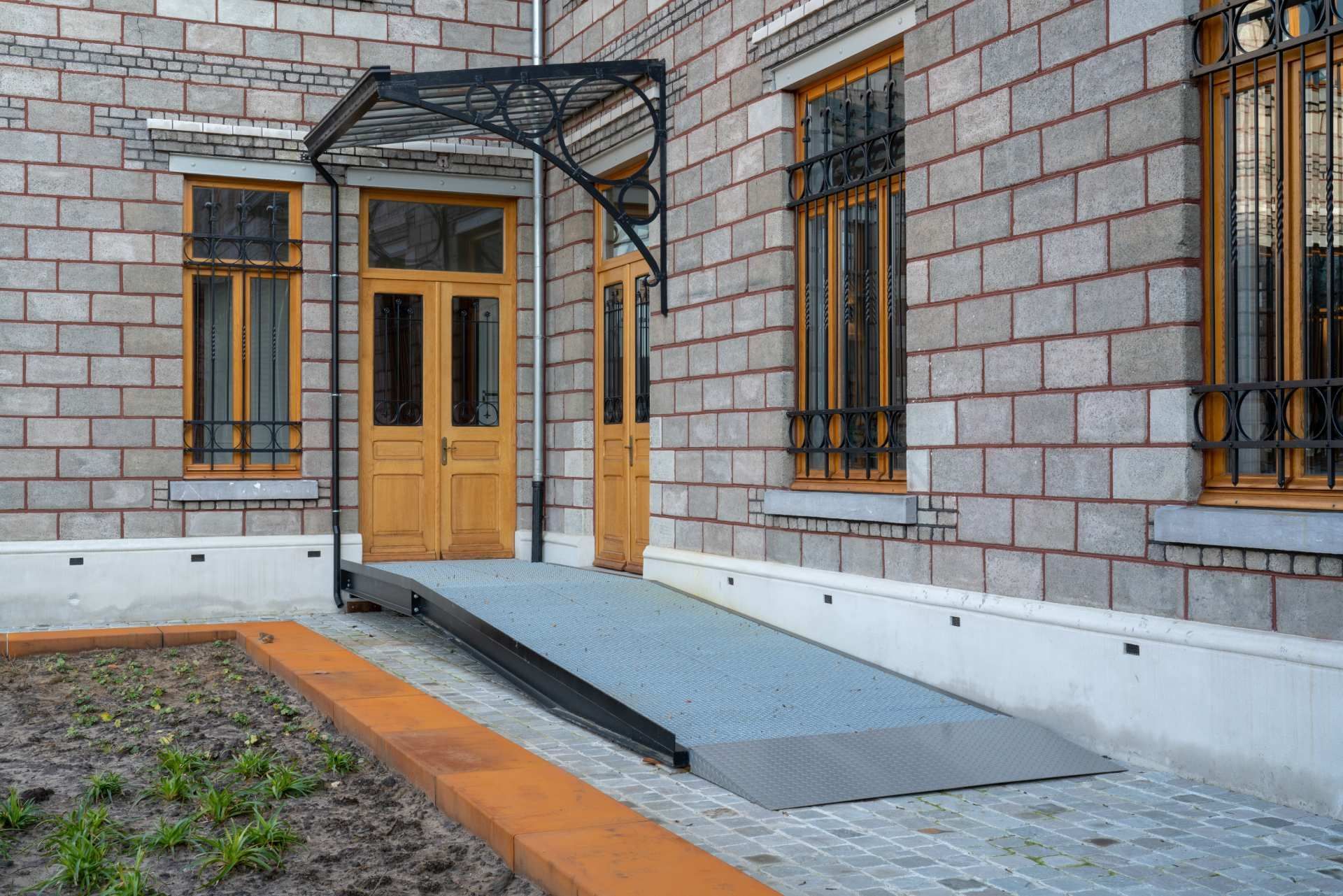 Ein Backsteingebäude mit einer Rampe, die zur Tür führt.