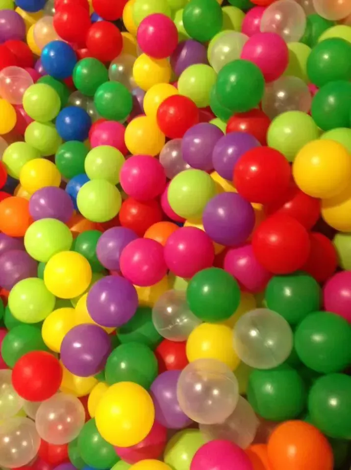 Pila de bolas de plástico de colores, incluidas las rojas, verdes, amarillas, rosas, moradas y transparentes.