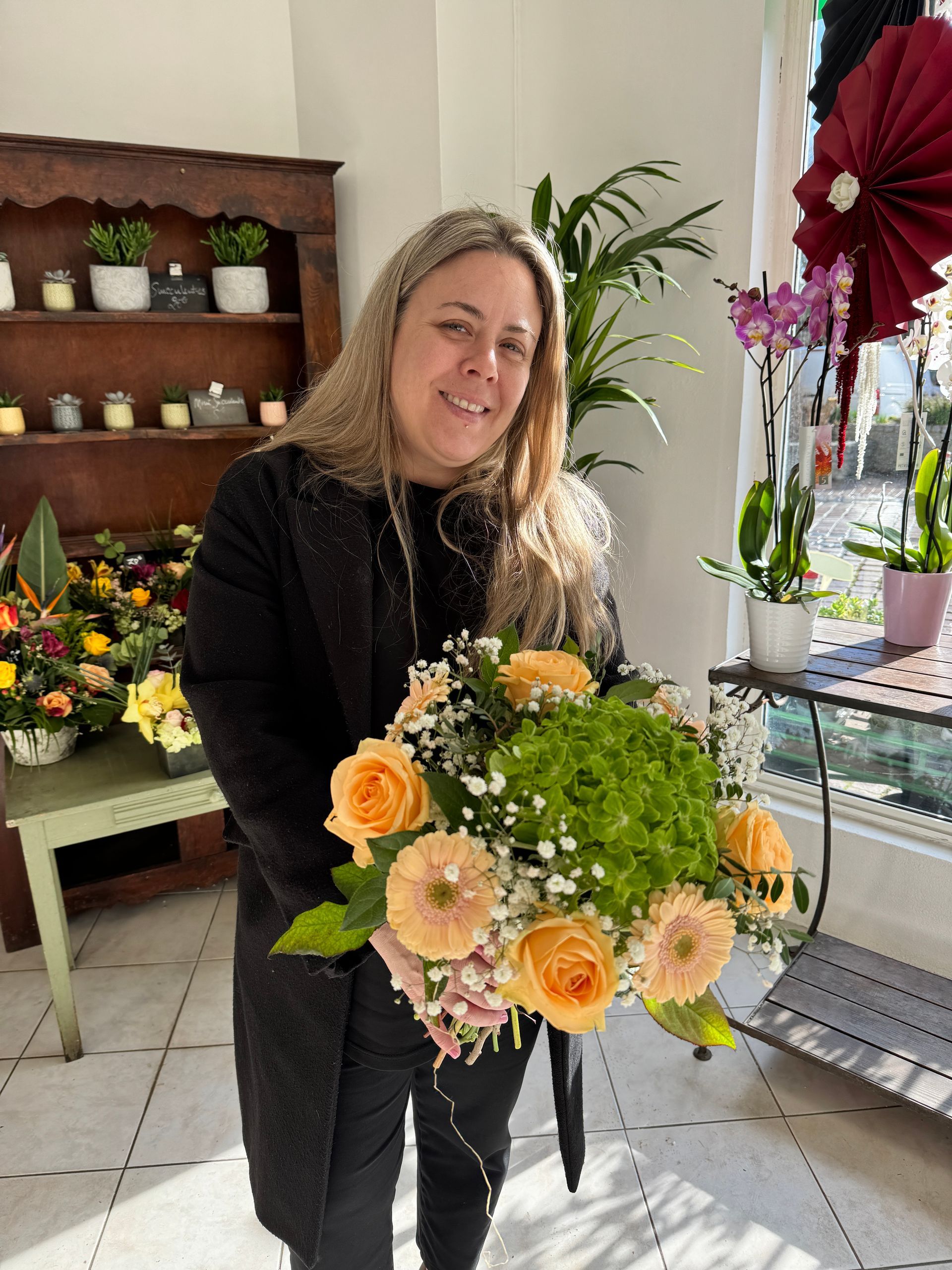Femme tenant un bouquet de fleurs orange
