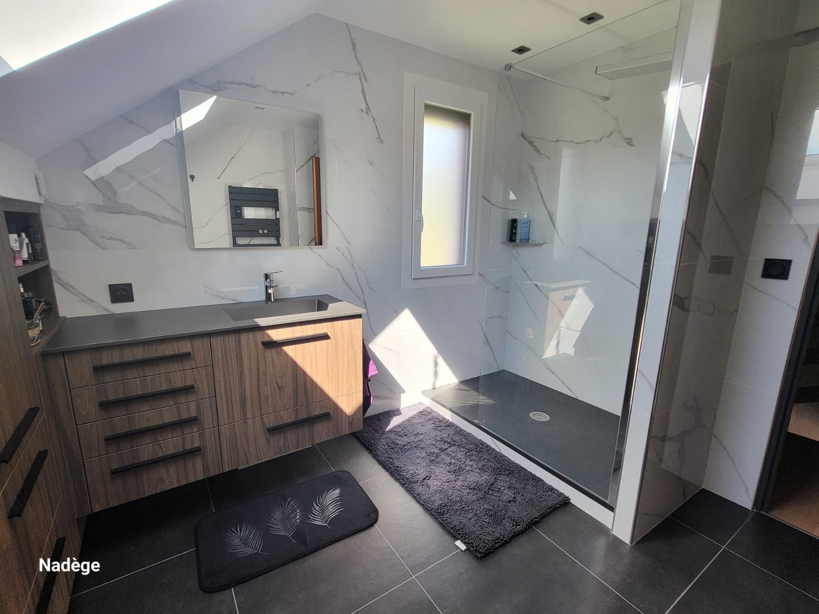 Salle de bains moderne noire et bois, douche à l'italienne, murs effet marbre