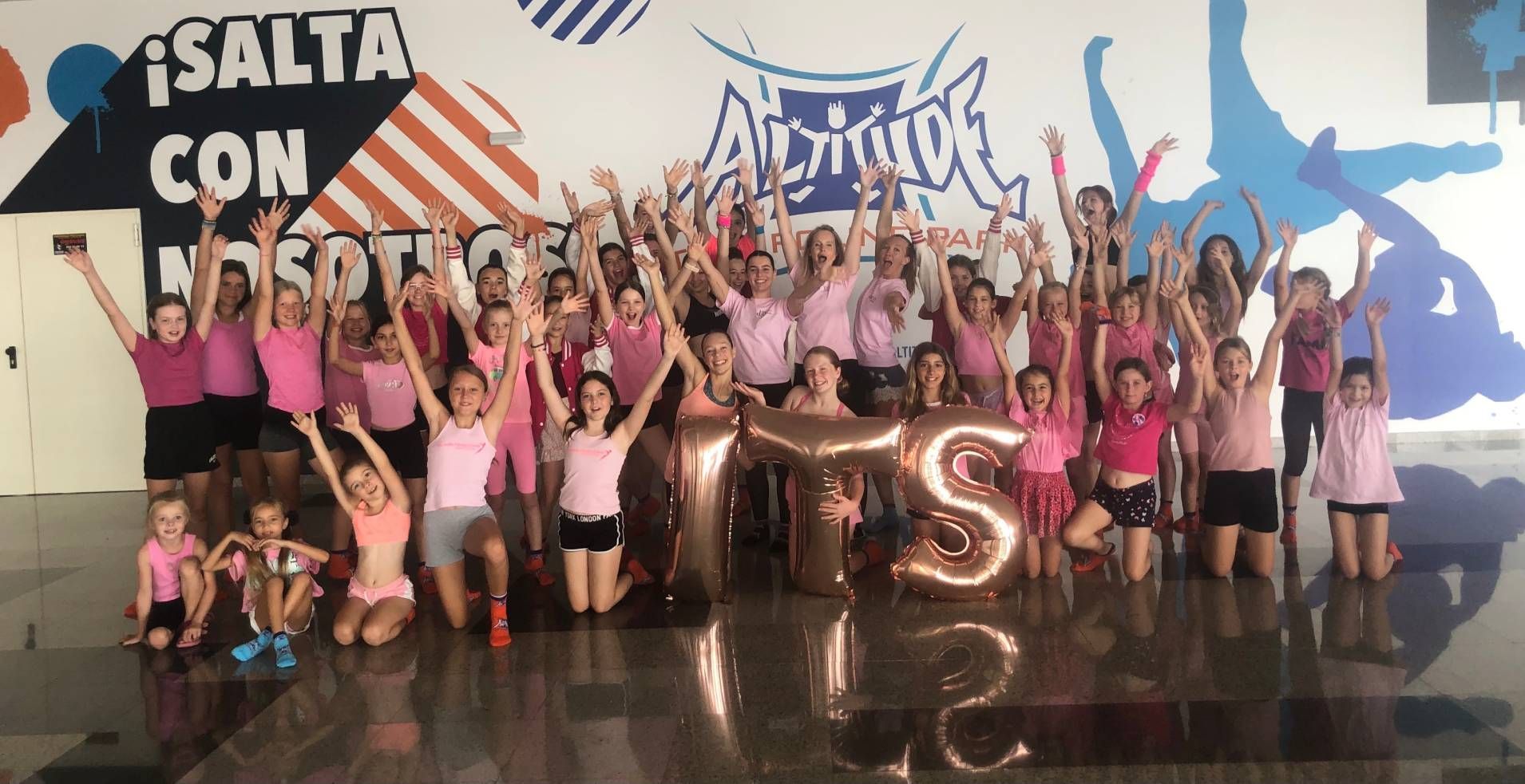 A group of young girls are posing for a picture in a gym.