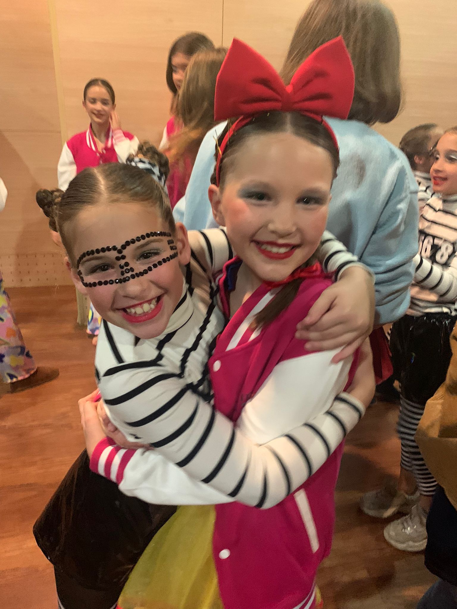 Two little girls are hugging each other in a room.