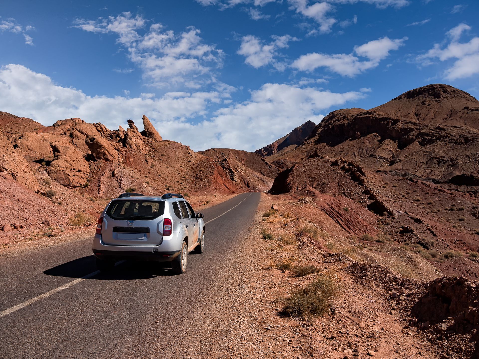 Voiture Dacia sur une route déserte